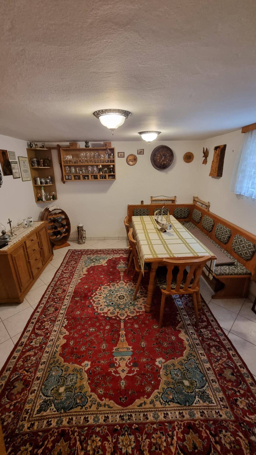 Gemütlicher Essbereich mit traditionellem Teppich, Holztisch und Eckbank.