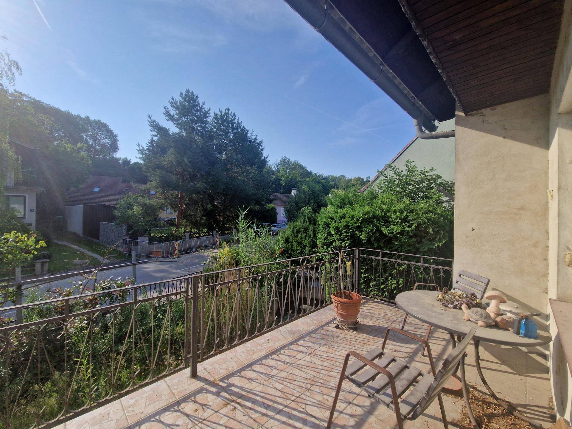 Sonniger Balkon mit Metallgeländer und Sitzgelegenheiten mit Blick auf die Umgebung.
