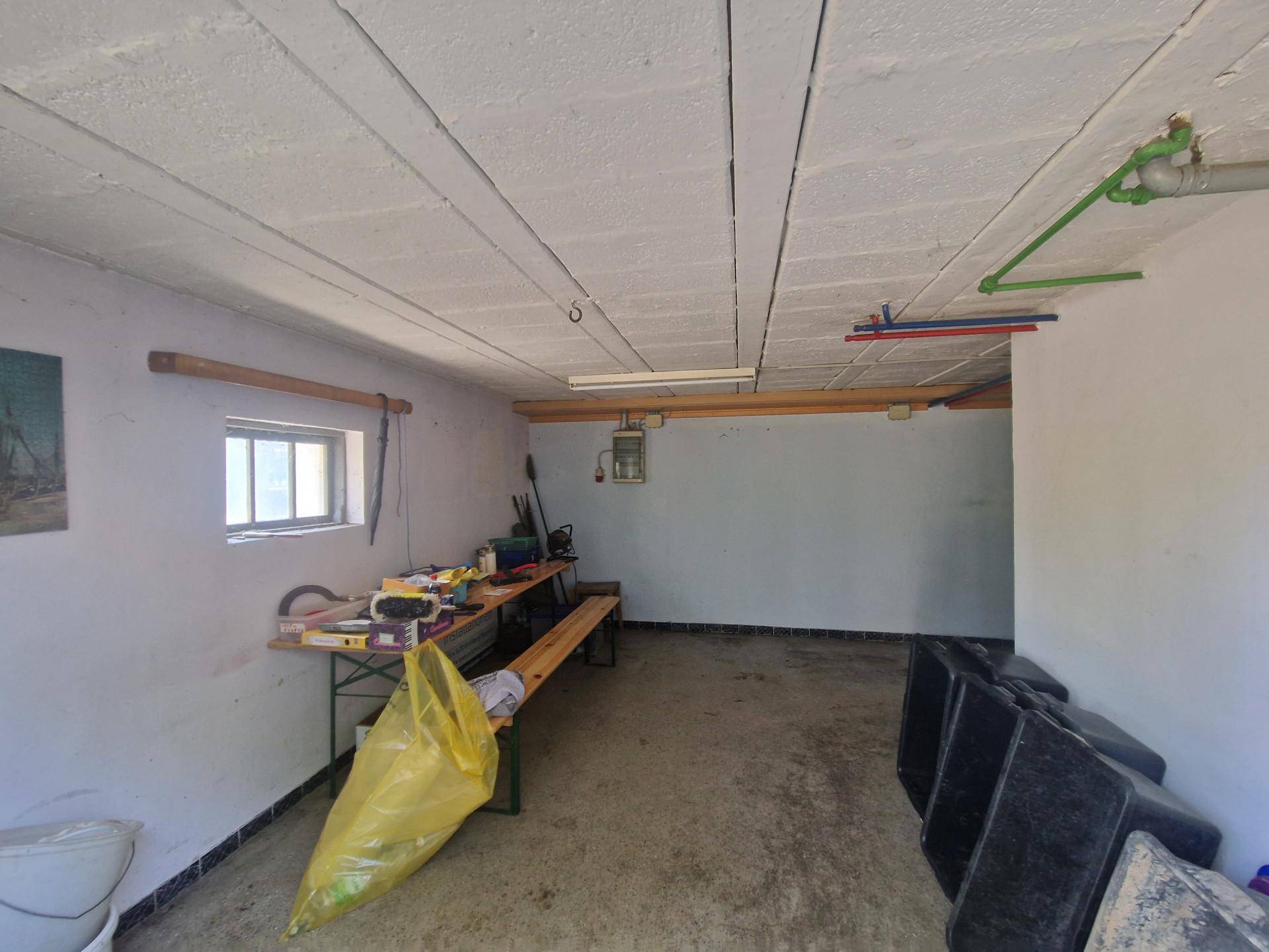 Geräumige Garage oder Werkstatt mit Werkbank und Fenster.