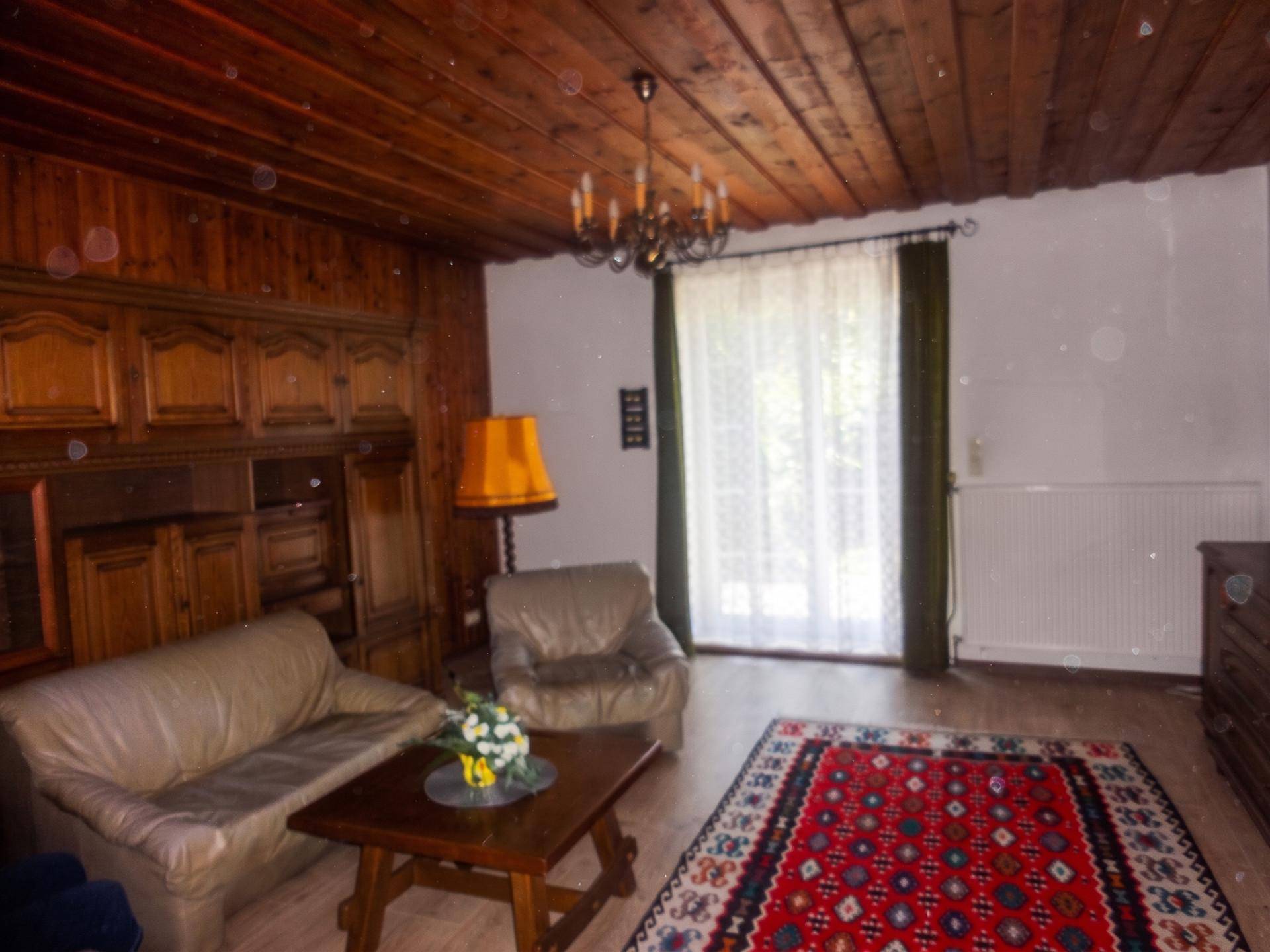 Rustikales Wohnzimmer mit Holzdecke, Holzvertäfelung und gemütlicher Sitzecke.