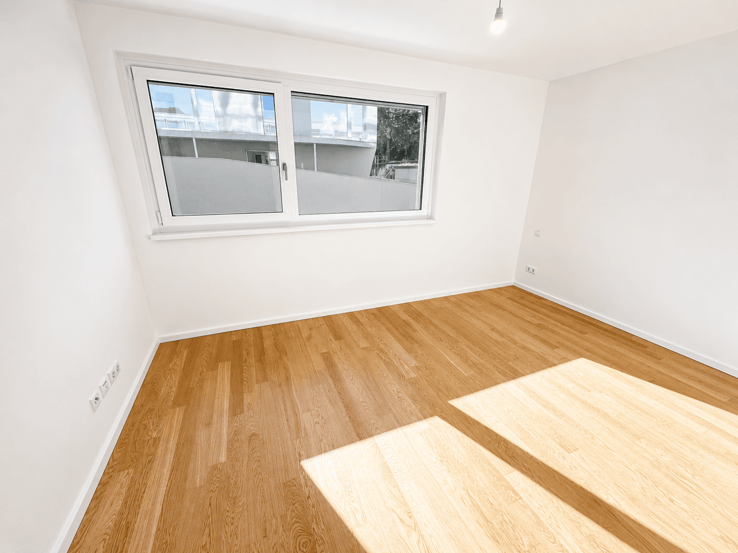 Geräumiges Schlafzimmer mit großen Fenstern, Holzboden und viel natürlichem Licht.