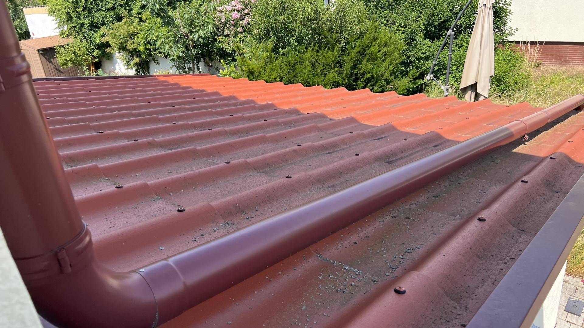 Nahaufnahme des roten Ziegeldachs mit Regenrinne und sichtbaren Dachziegeln.
