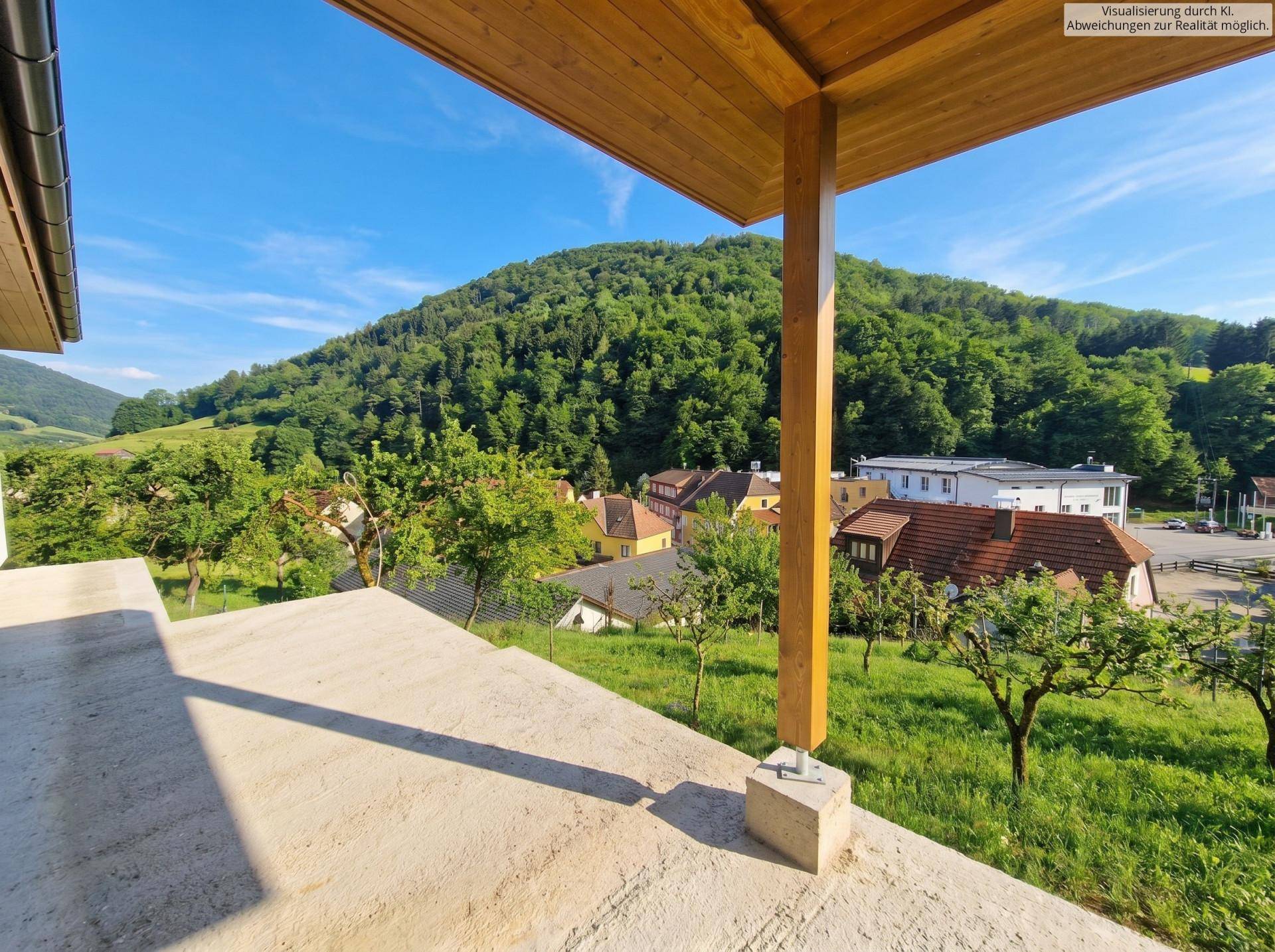 Geräumige überdachte Terrasse mit Holzstützen und Panoramablick auf die umliegende Natur und Häuser.