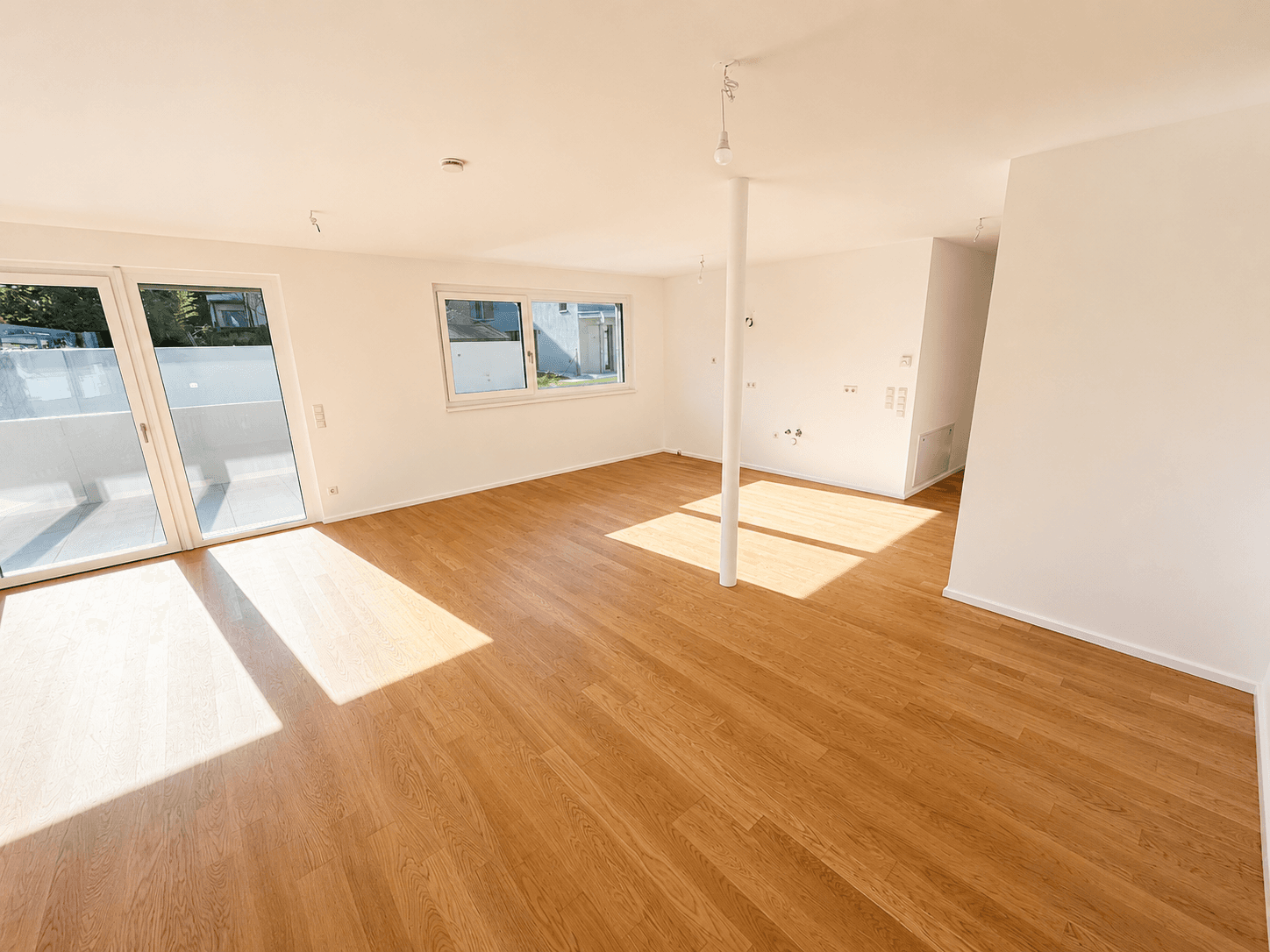 Geräumiger, heller Wohnbereich mit Holzboden und direktem Zugang zur Terrasse oder zum Balkon.