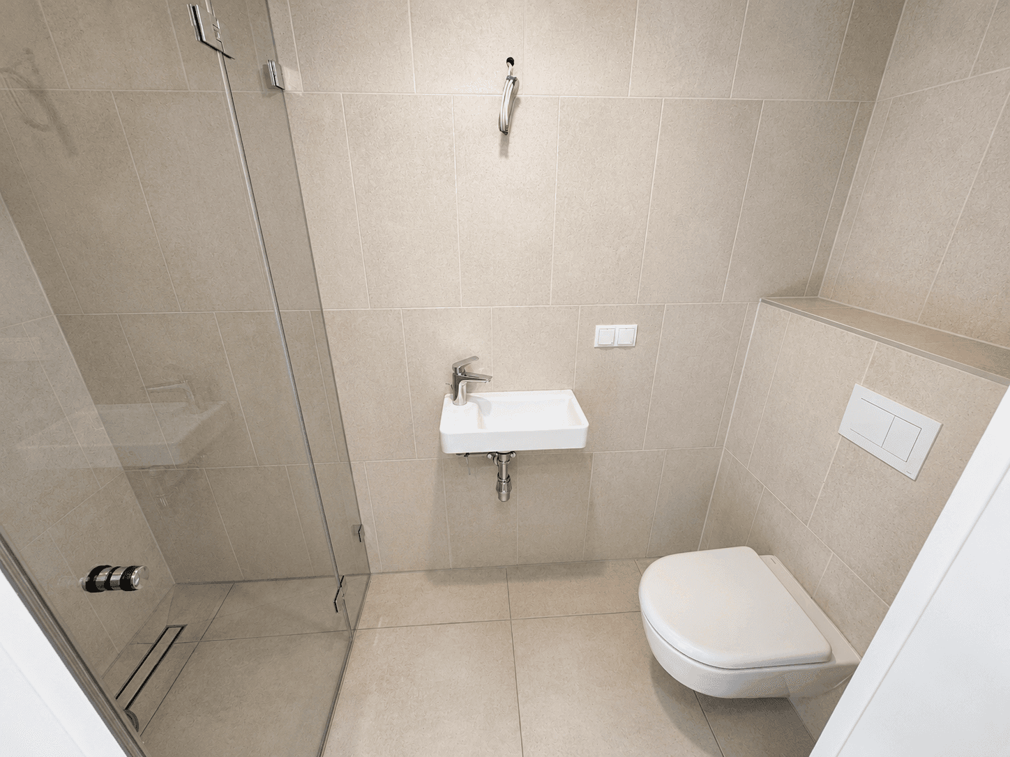 Gäste-WC mit begehbarer Dusche, modernem Waschbecken und Wand-WC in neutralen Grautönen.