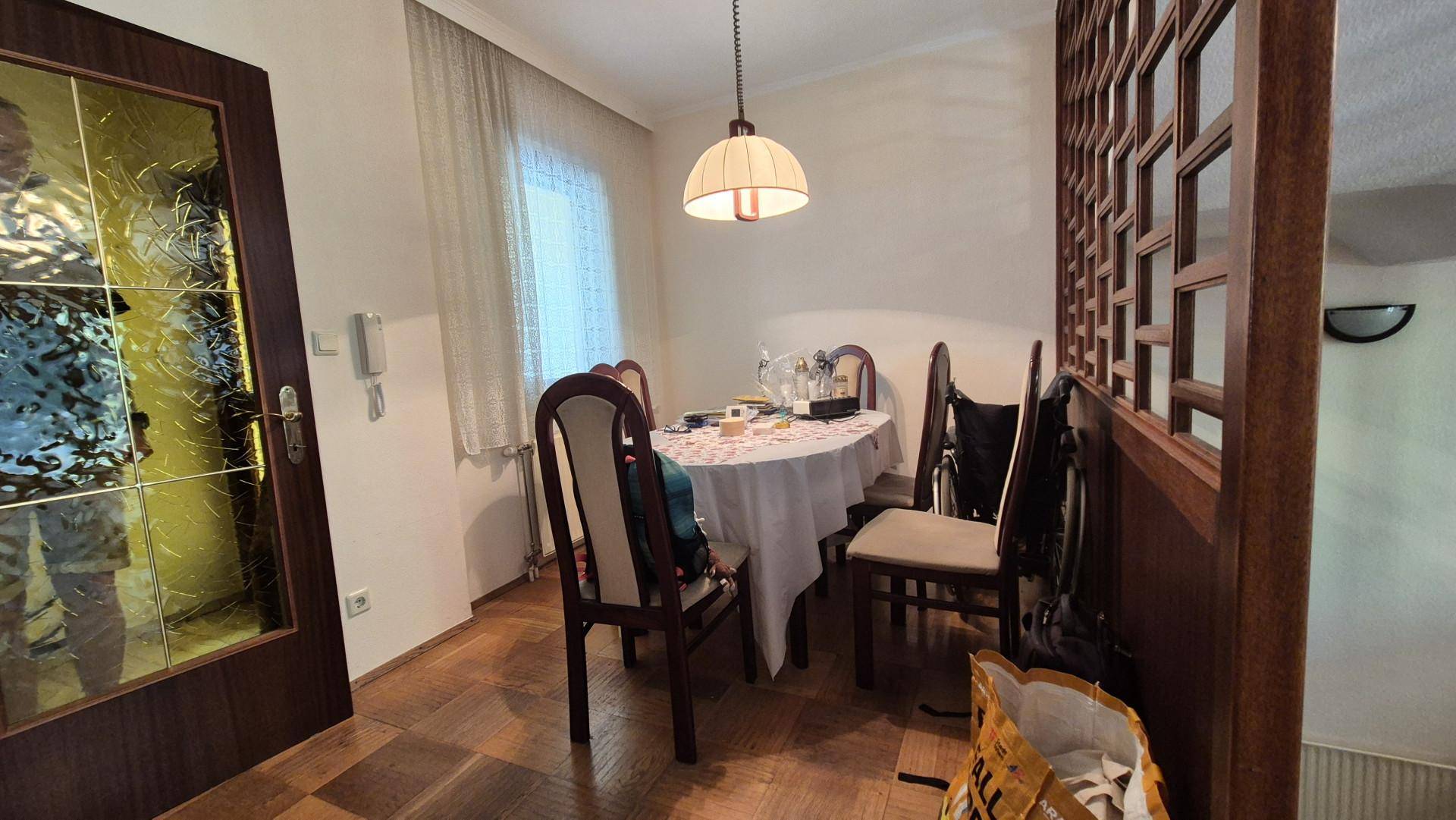 Gemütlicher Essbereich mit Holztisch, Stühlen und dekorativem Raumteiler aus Holz.