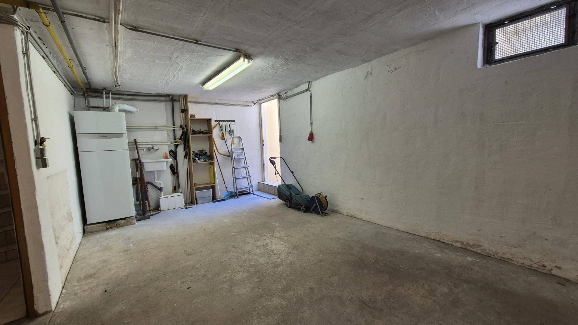 Geräumiger Kellerraum mit Betonboden, kleinem Fenster und Stauraum für diverse Gegenstände.