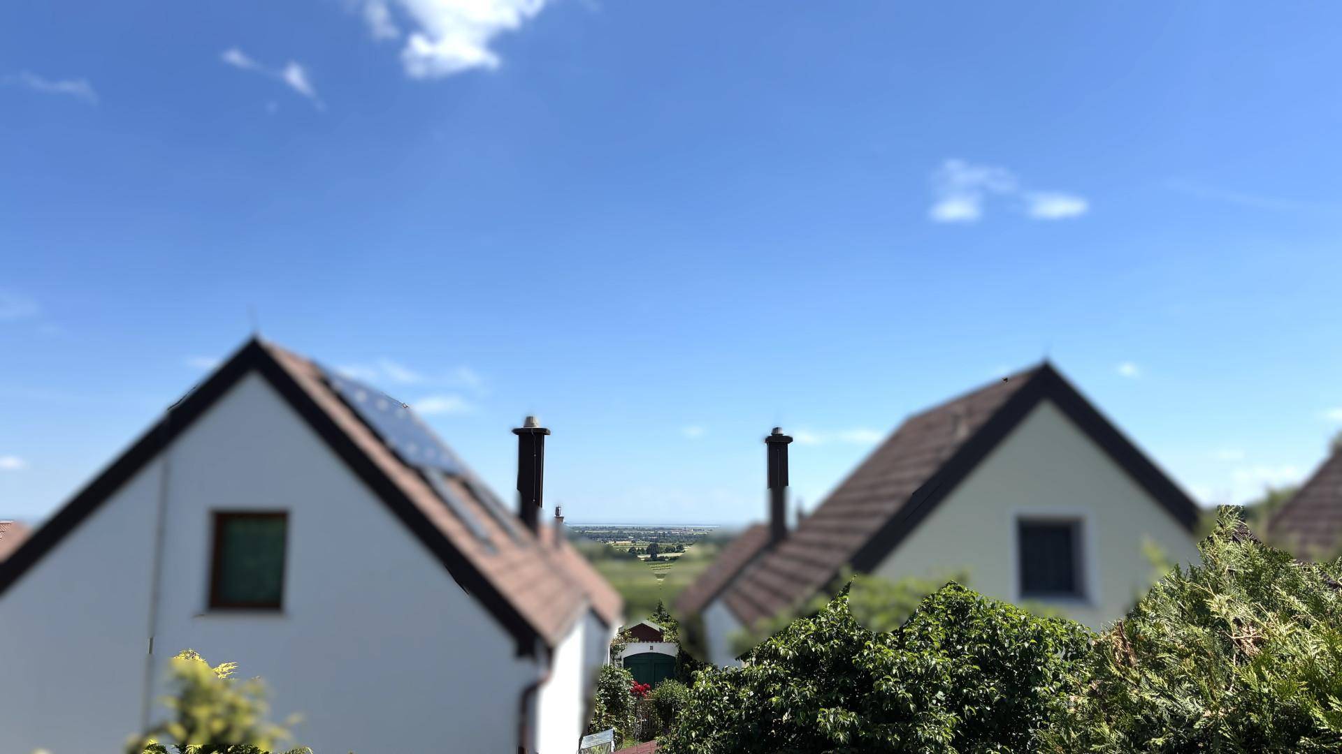 Weitblick über Dächer und die umliegende Landschaft unter einem klaren blauen Himmel.