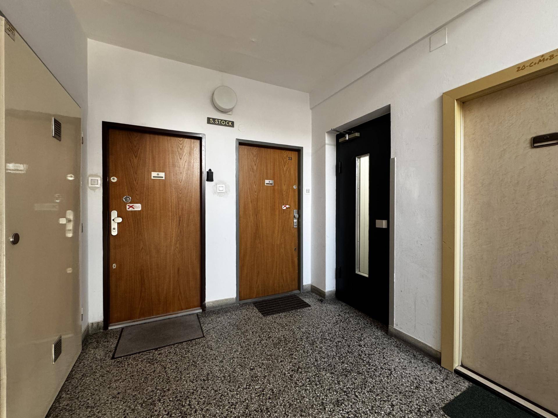 Gemeinschaftlicher Flur mit mehreren Wohnungstüren und Terrazzoboden.