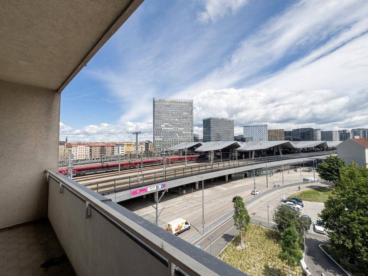 Balkon mit weitem Blick auf die Stadt, Bahngleise und moderne Gebäude.