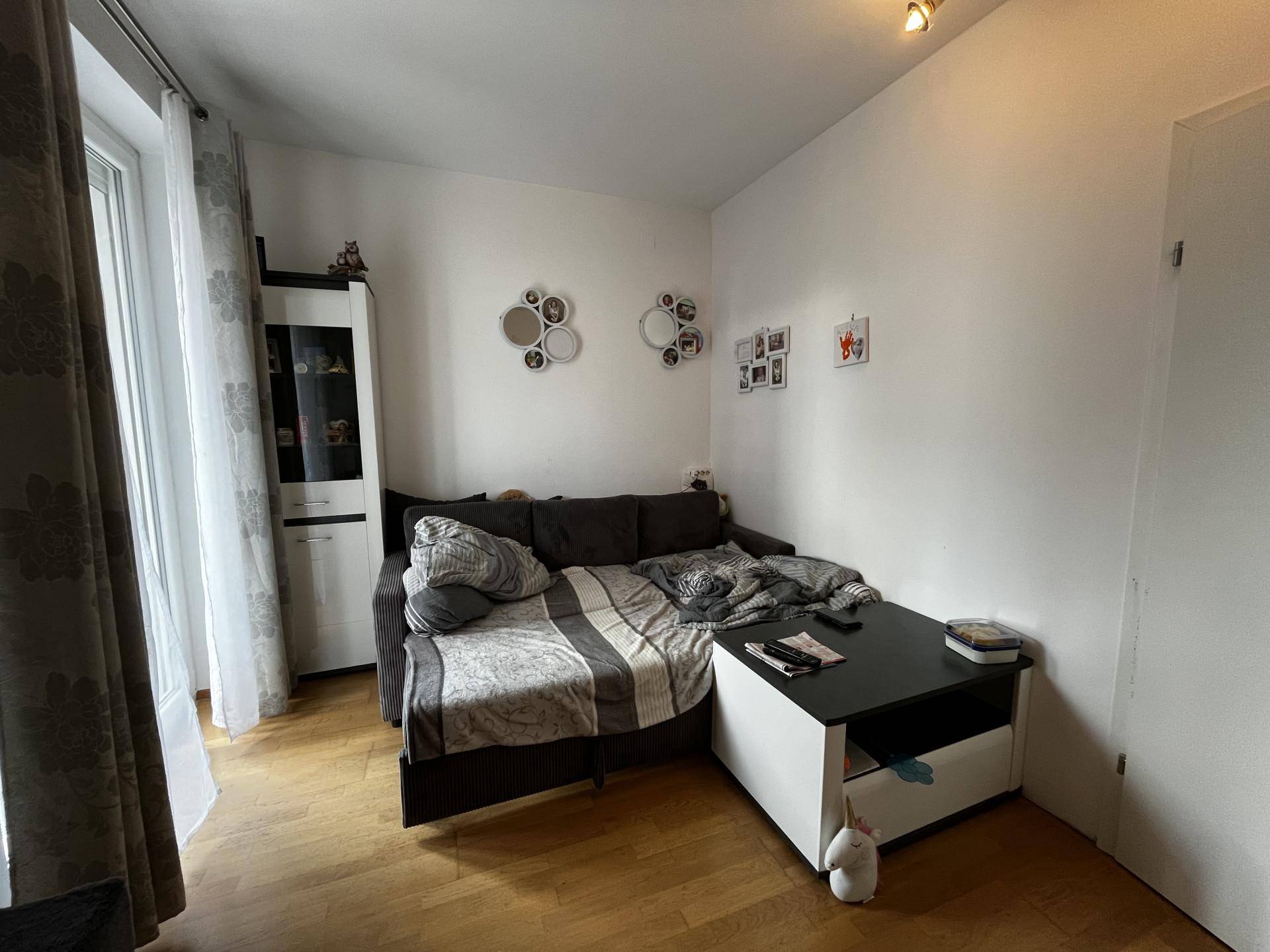 Gemütliches Wohnzimmer mit Sofa, Couchtisch und hellem Holzfußboden.