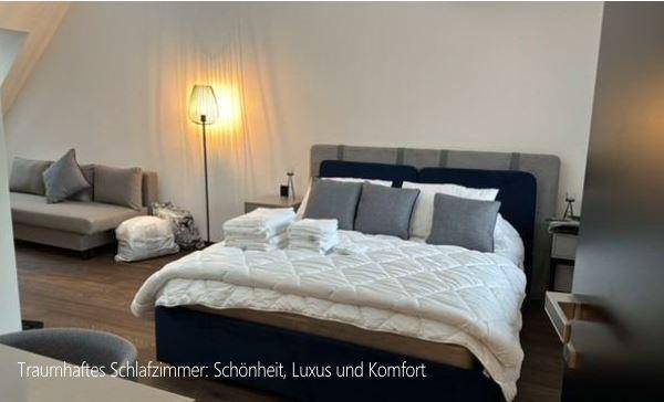 Gemütliches Schlafzimmer mit modernem Bett, Nachttischen und einer Stehlampe unter Dachschräge.