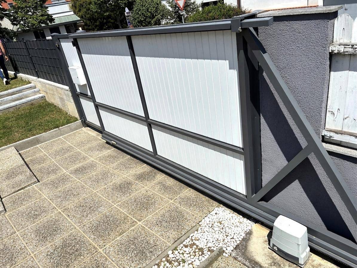 Modernes Schiebetor aus Metall und Kunststoff für die Zufahrt zum Grundstück.