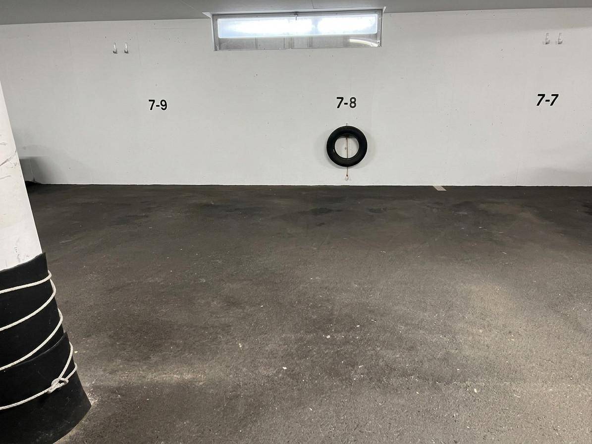 Tiefgarage mit nummerierten Stellplätzen und einem Fenster für Belüftung.