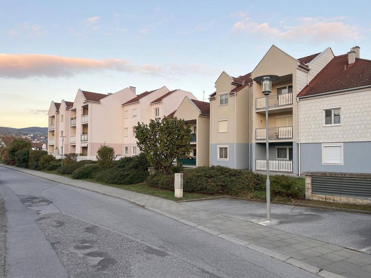 Reihe von Mehrfamilienhäusern mit Balkonen und traditioneller Architektur entlang einer Straße.
