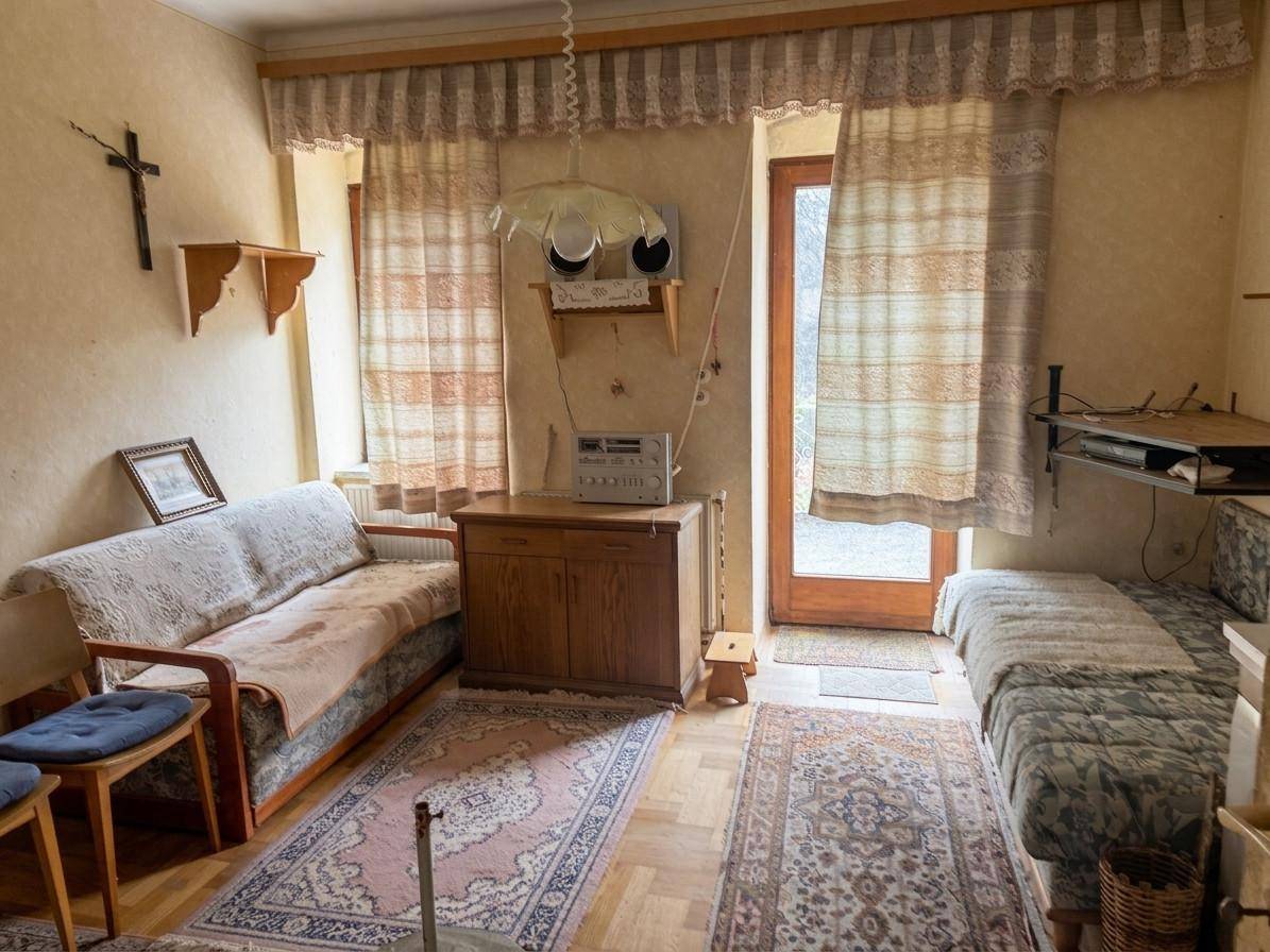 Gemütliches Wohnzimmer mit traditionellen Möbeln, Teppichen und direktem Zugang zum Außenbereich.