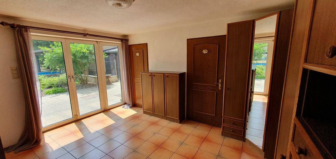 Schlafzimmer mit direktem Zugang zum Garten durch große Glastüren.