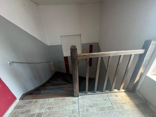 Holztreppe mit Geländer in einem Flur, der in die oberen Stockwerke des Hauses führt.