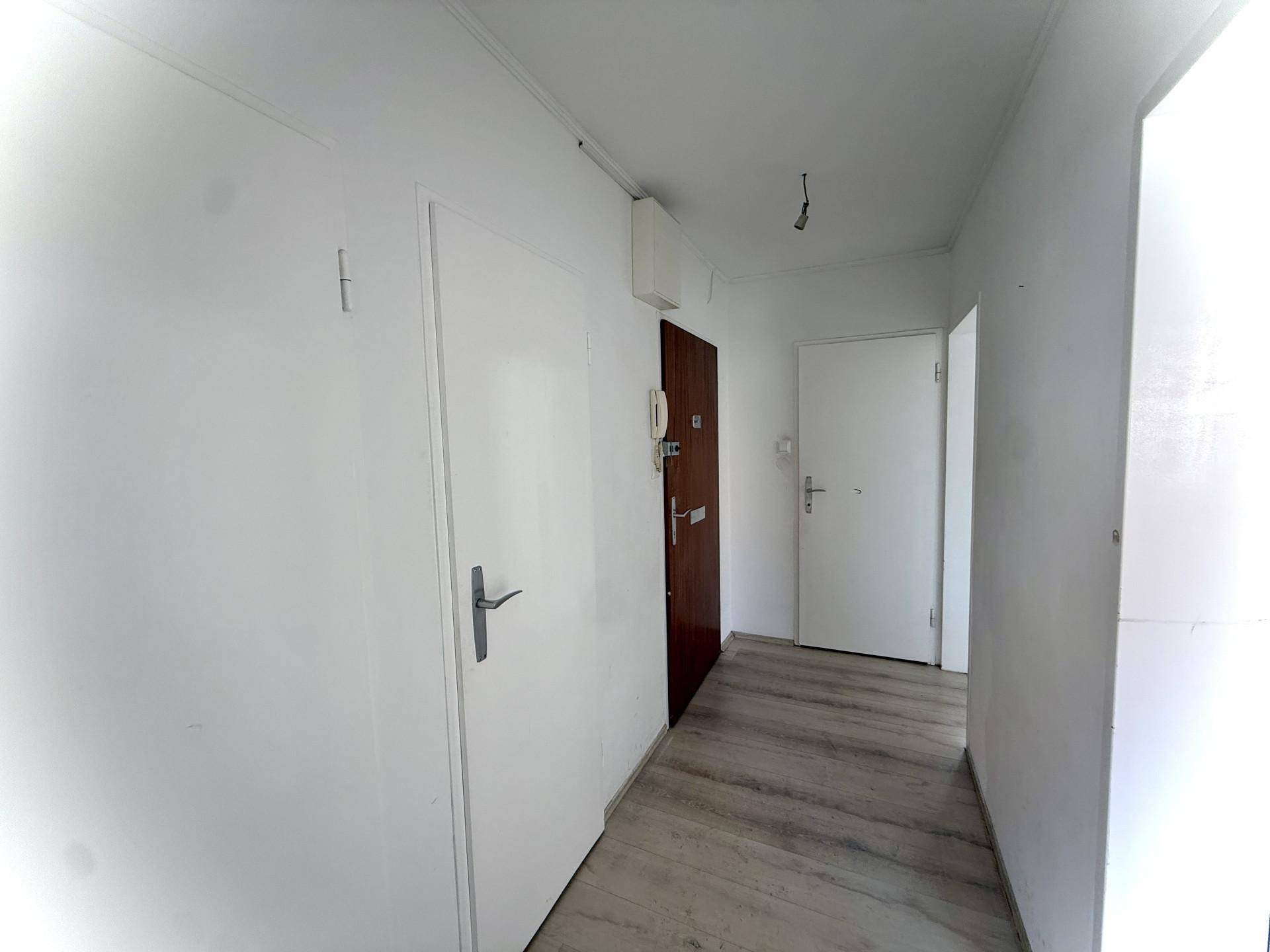 Heller Flur mit Laminatboden und mehreren Türen, der verschiedene Räume verbindet.