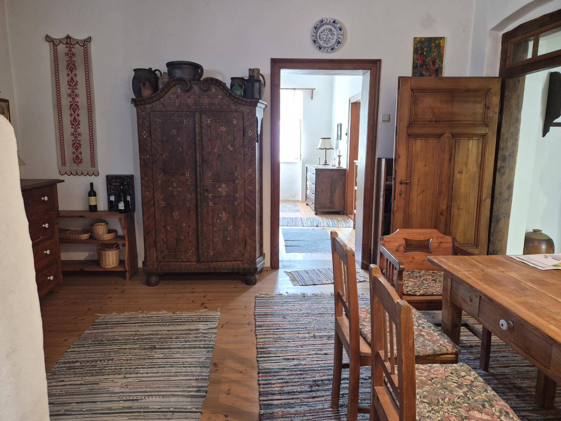 Geräumiger Wohn-Essbereich mit Holzboden, rustikalen Möbeln und traditionellen Teppichen.