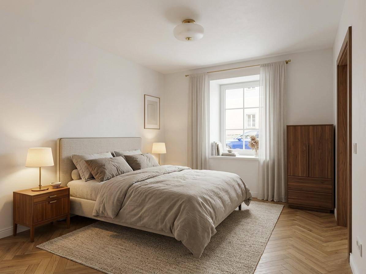 Helles Schlafzimmer mit Holzboden, großem Bett und Fenster mit Blick nach draußen.