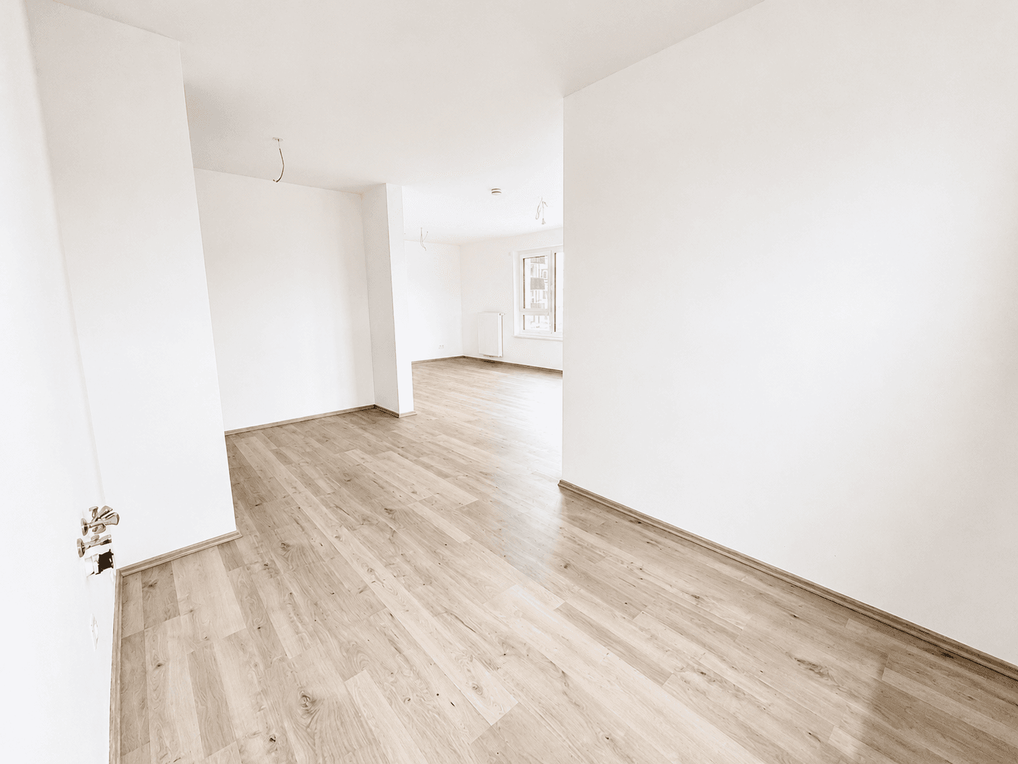 Heller, leerer Flur mit Laminatboden, der zu weiteren Räumen in der Wohnung führt.