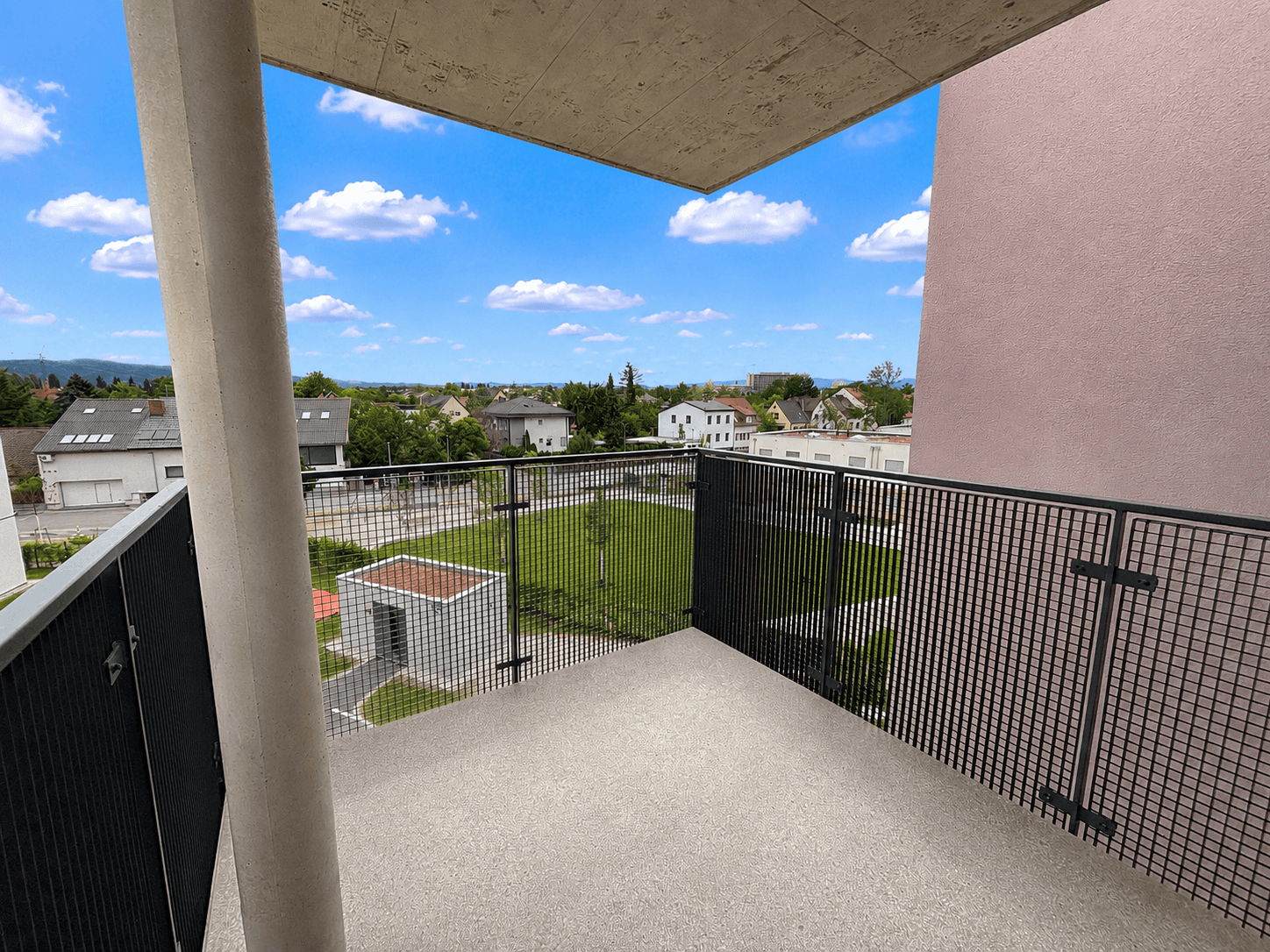 Geräumiger Balkon mit Metallgeländer und weitem Blick über die Umgebung.