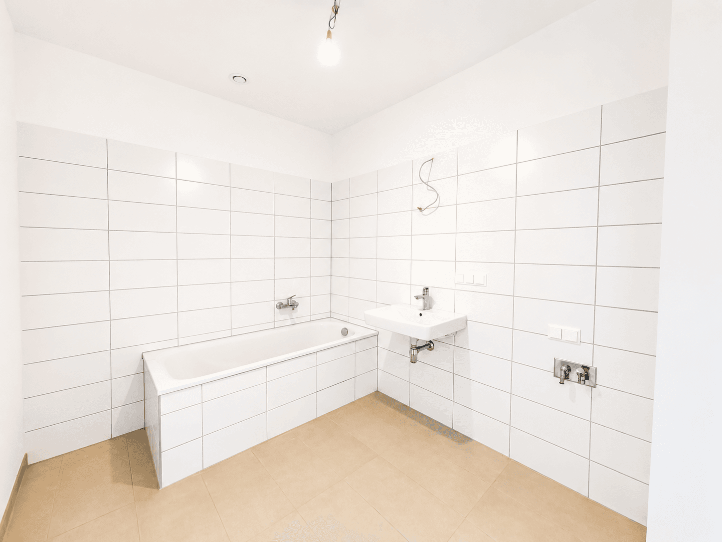 Modernes Badezimmer mit weiß gefliesten Wänden, Badewanne und Waschbecken.