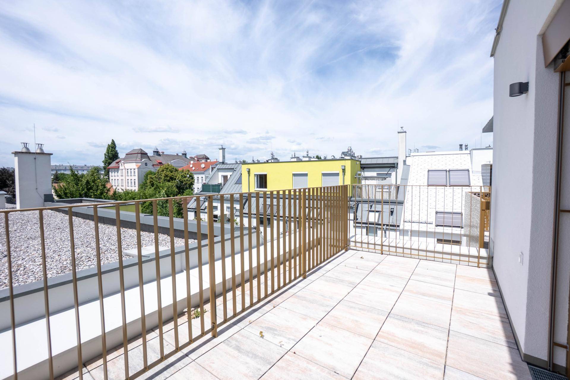 Großer Balkon mit einfacher Brüstung und weitem Blick über die umliegende Stadtlandschaft.