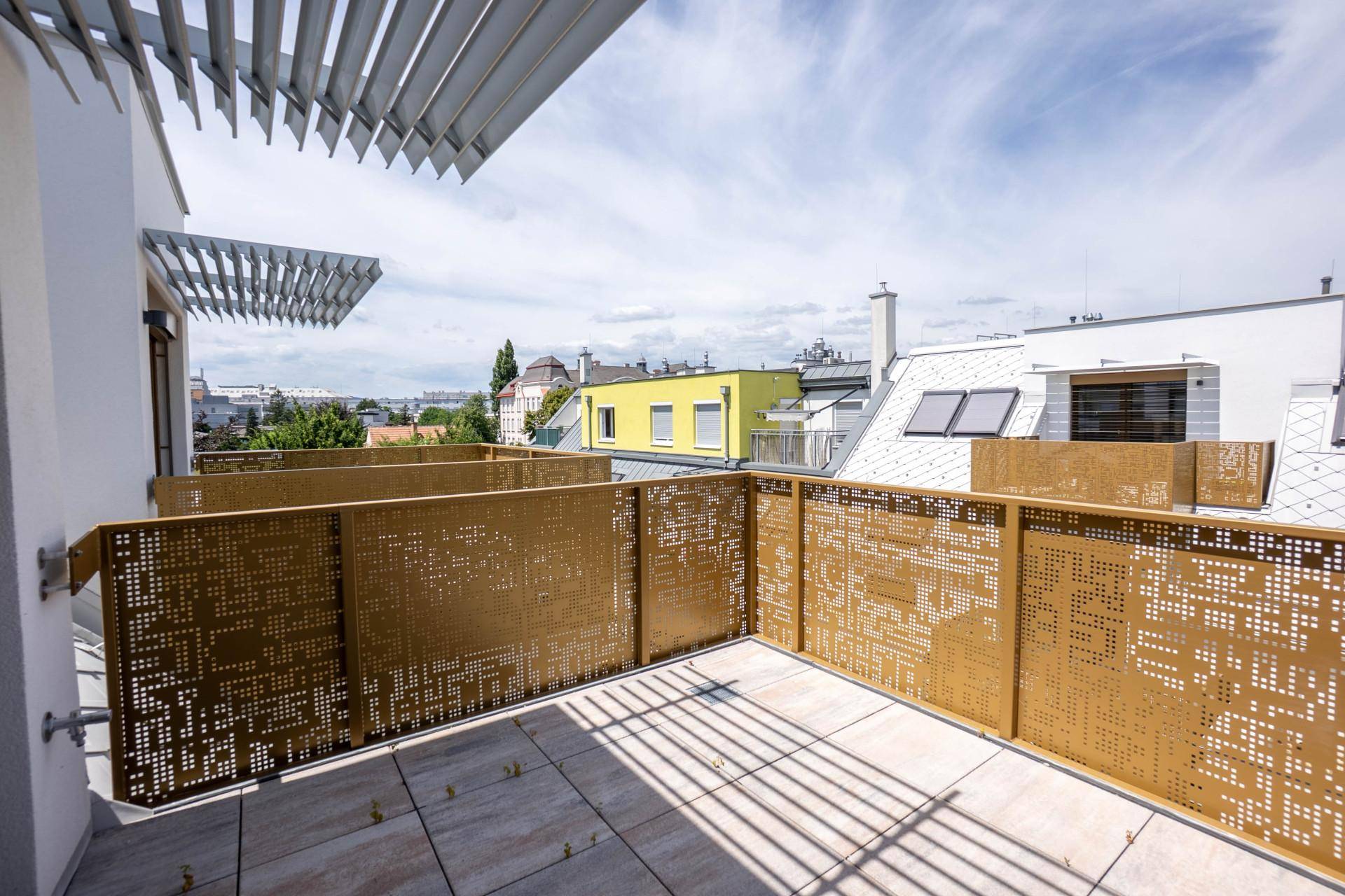 Geräumiger Balkon mit einzigartigem perforiertem goldenem Geländer und weitem Blick über die Stadt.