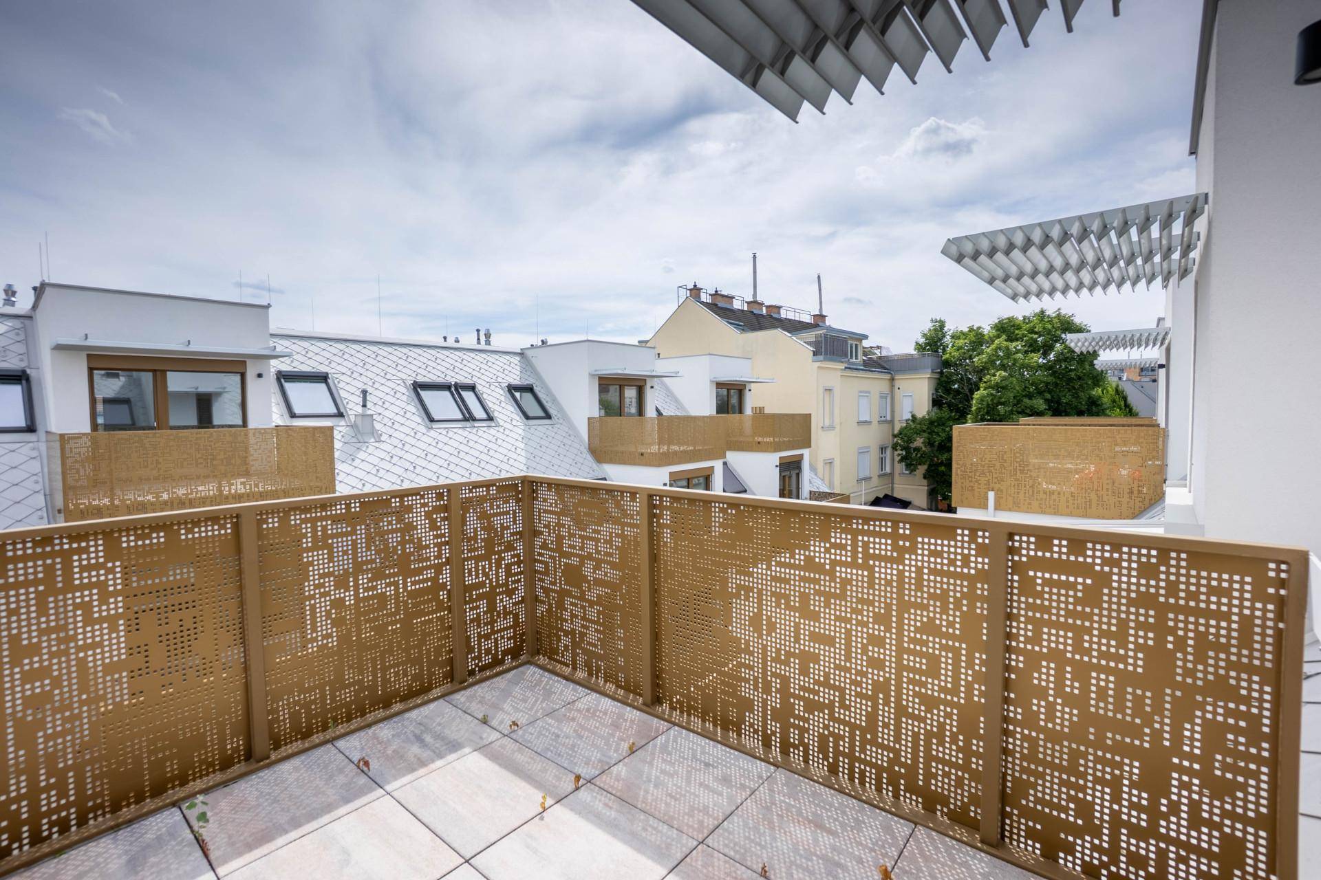 Geräumige Dachterrasse mit modernen perforierten Metallgeländern und Blick auf die Stadt.