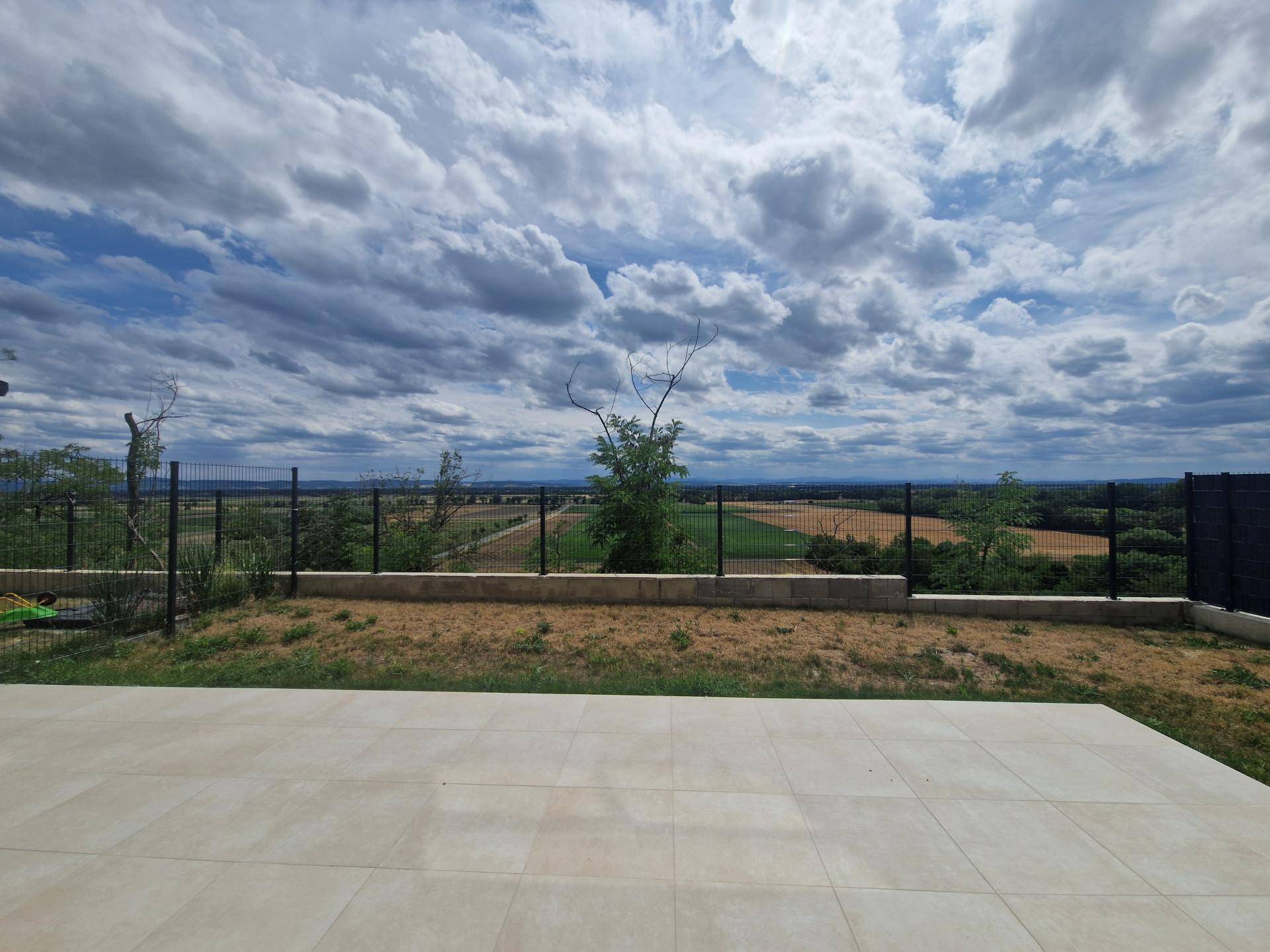 Gepflasterte Terrasse mit weitem Blick über die Felder und die umliegende Natur.