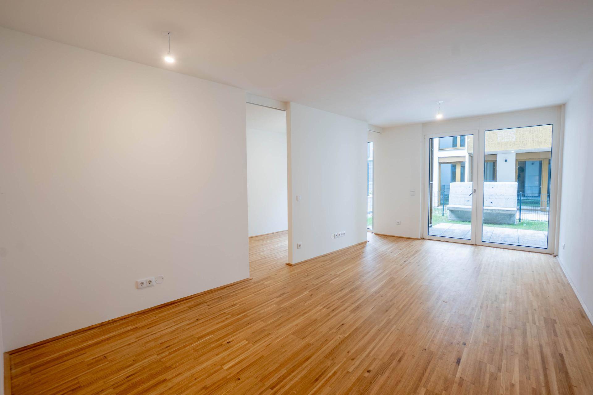 Heller Wohnbereich mit Parkettboden und großen Fenstern zum Garten oder zur Terrasse.