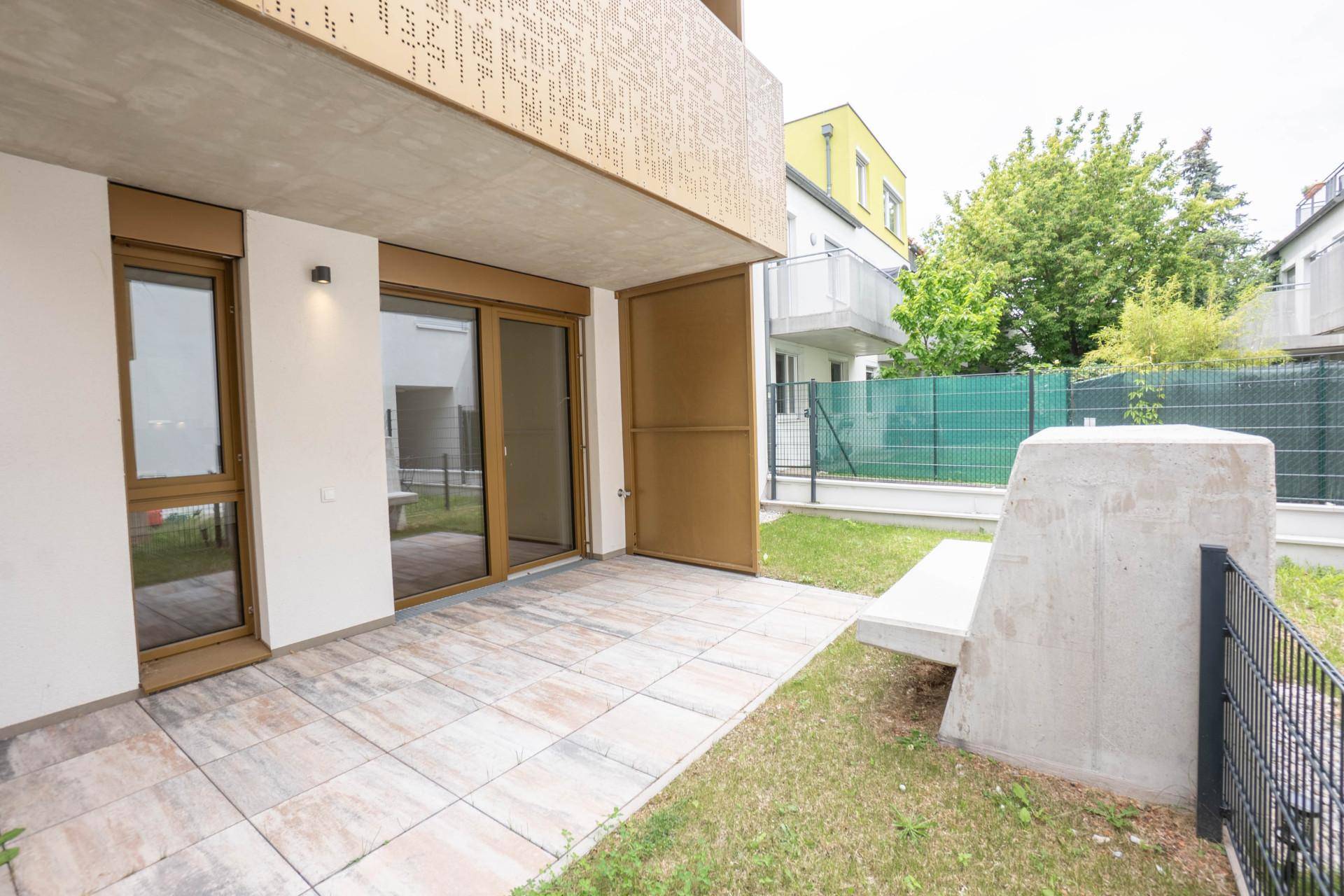 Geräumige Terrasse mit Fliesenboden und Zugang zum privaten Gartenanteil.