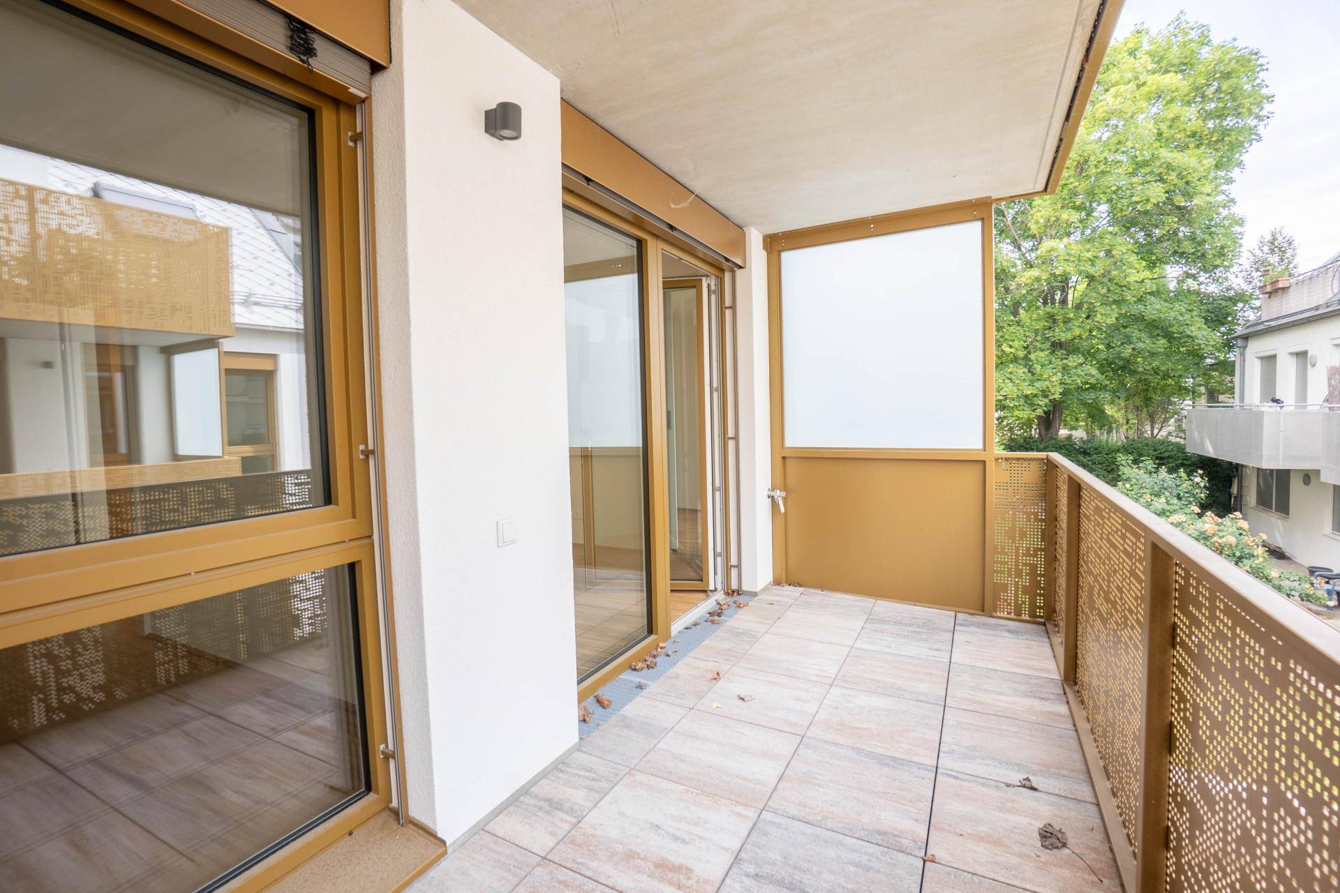 Geräumiger Balkon mit Fliesenboden und dekorativem Geländer, ideal für entspannte Stunden im Freien.