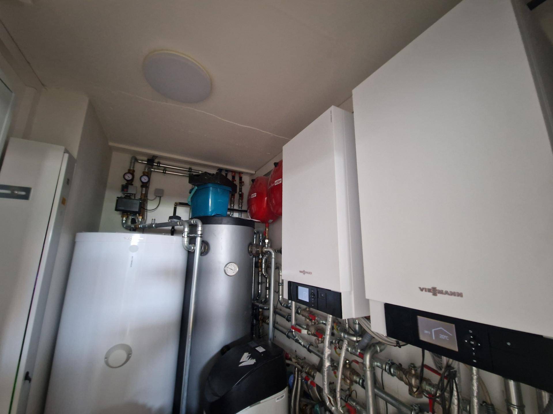 Heizungsraum mit modernen Viessmann-Heizkesseln und Warmwasserspeicher für effiziente Wärmeversorgung.