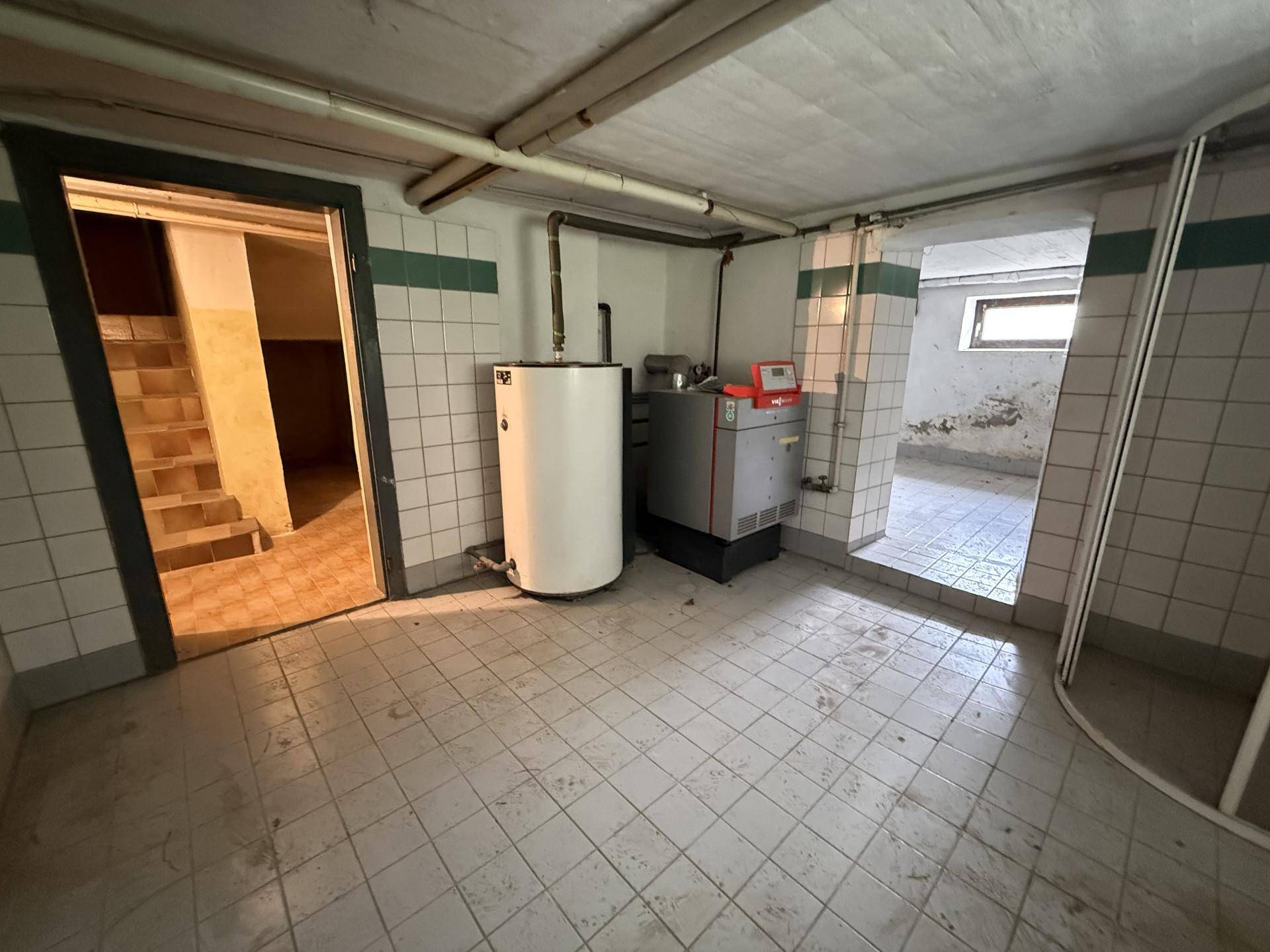 Heizungsraum im Keller mit Boiler und Heizungsanlage, bereit für die Wartung.