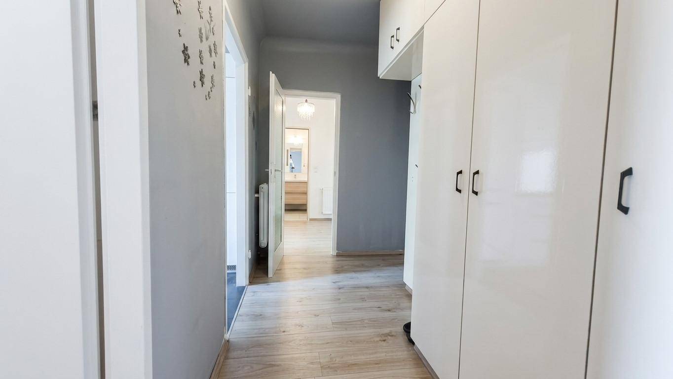 Langer Flur mit Einbauschränken, Holzboden und Zugang zu verschiedenen Zimmern.