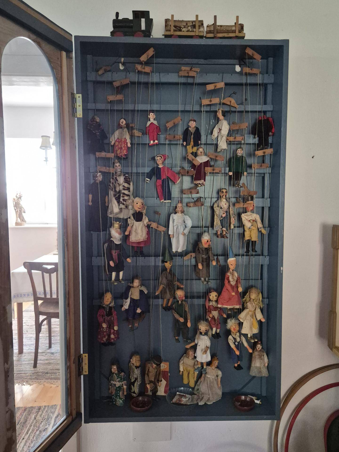 Vitrine mit einer Sammlung von Marionetten und traditionellen Puppen.