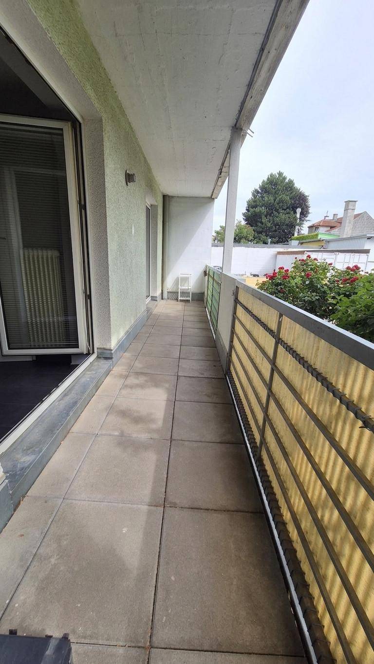 Geräumiger Balkon mit Fliesenboden und Blick auf die Umgebung, mit Sichtschutz.