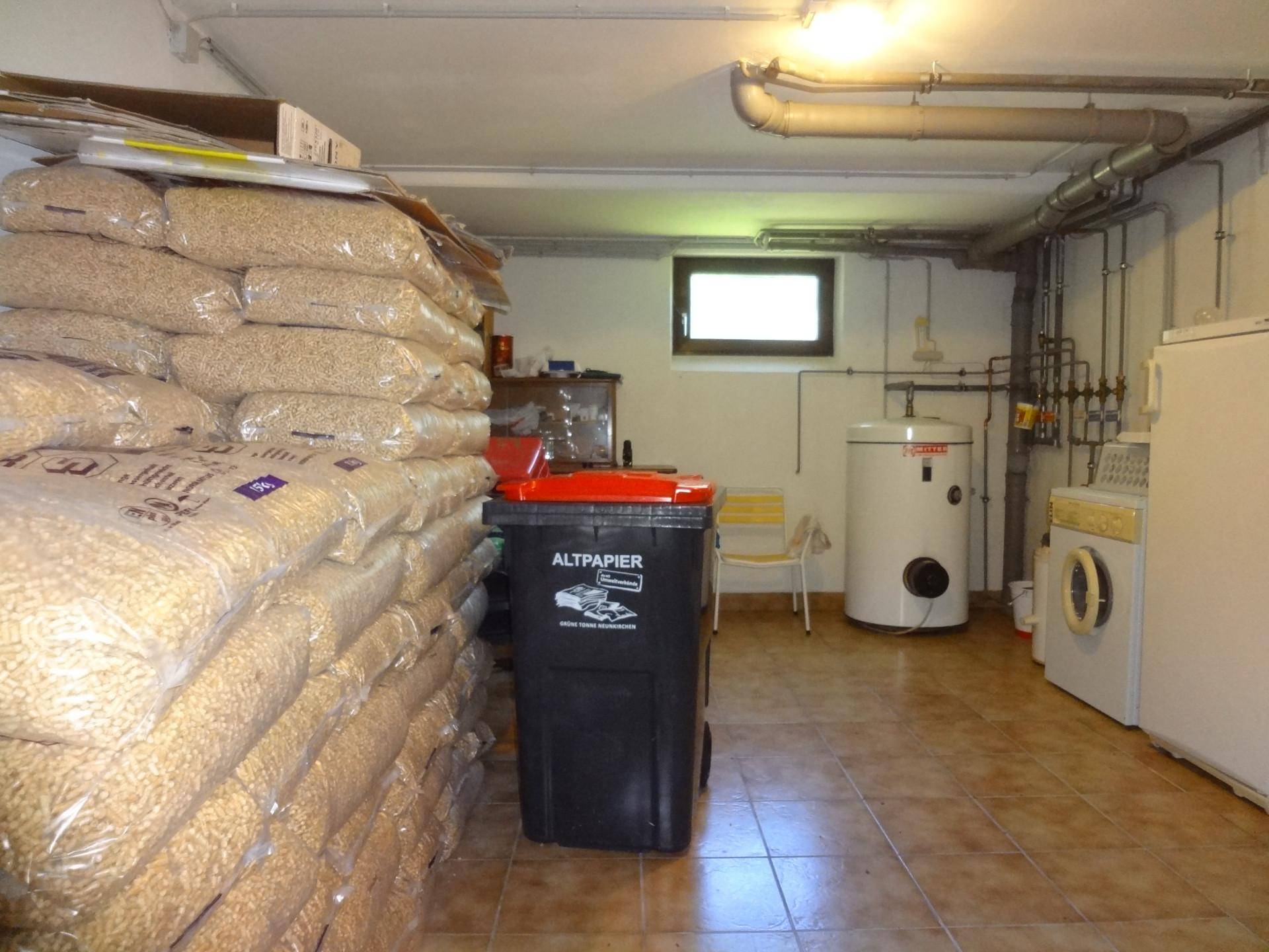 Hauswirtschaftsraum im Keller mit Heizungsanlage, Waschmaschine und Lagerfläche.