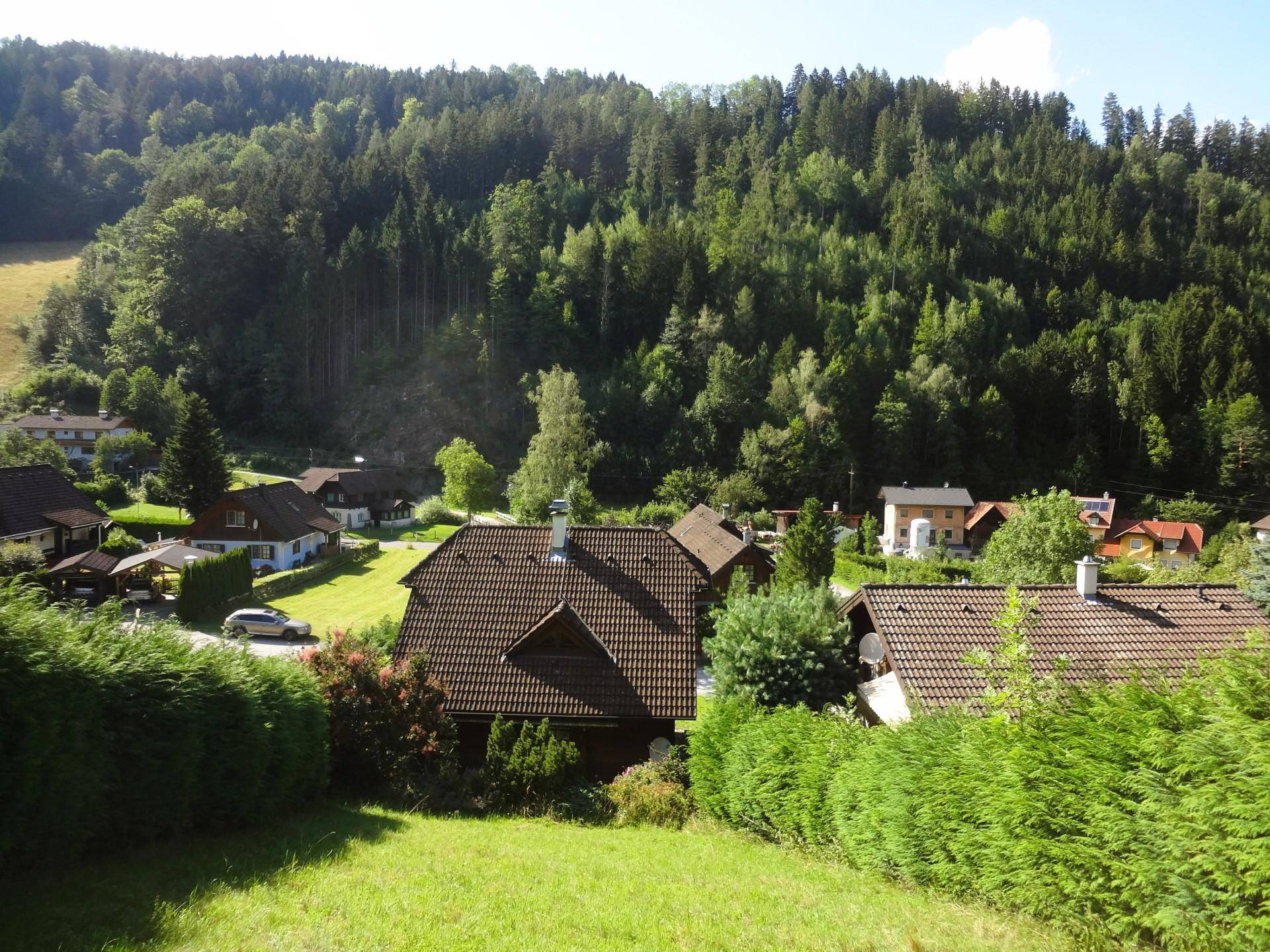 Panoramablick auf die umliegende Wohnsiedlung mit grünen Hügeln und Wäldern.