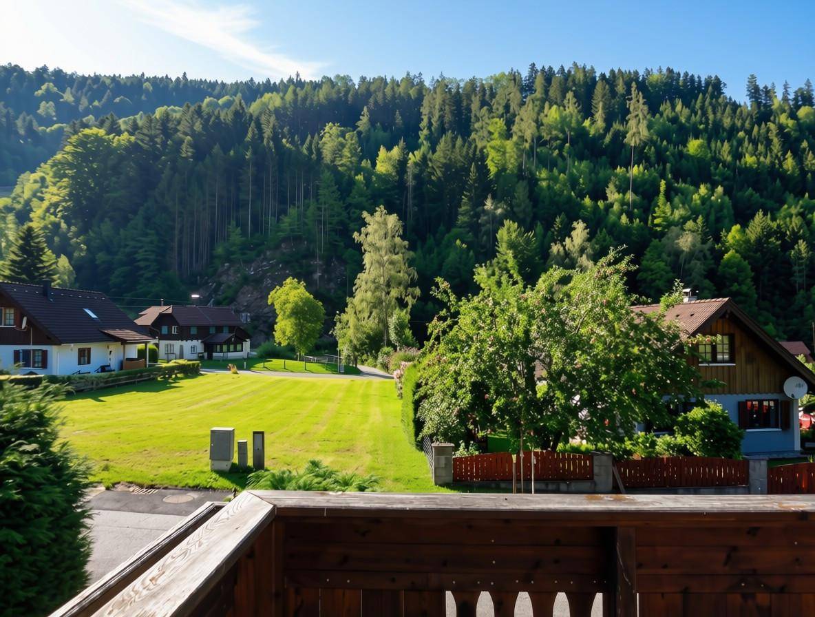 Weitläufiger Blick über die grüne Landschaft mit weiteren Häusern und bewaldeten Hügeln.