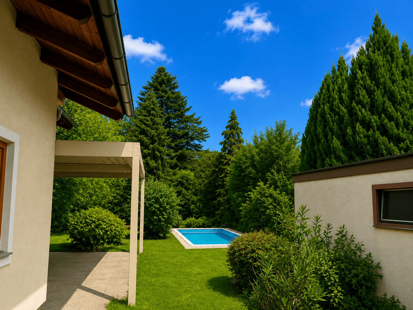 Gepflegter Gartenbereich mit einem erfrischenden Pool, umgeben von üppigem Grün und hohen Bäumen.