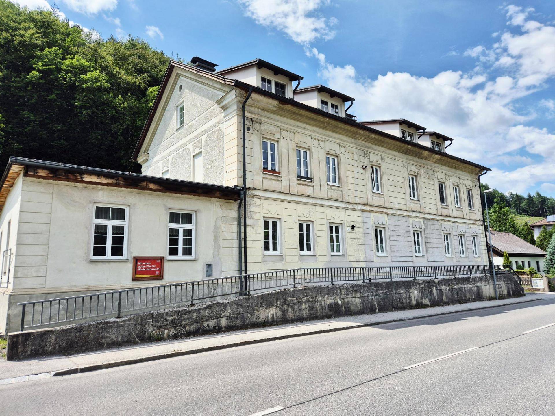 Seitenansicht des historischen Gebäudes mit einer Rampe für barrierefreien Zugang und Blick auf die Straße.
