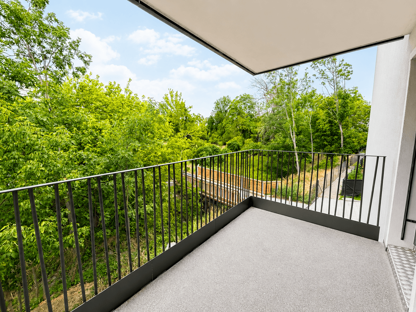 Geräumiger Balkon mit Metallgeländer und weitem Blick ins Grüne, ideal zum Entspannen.