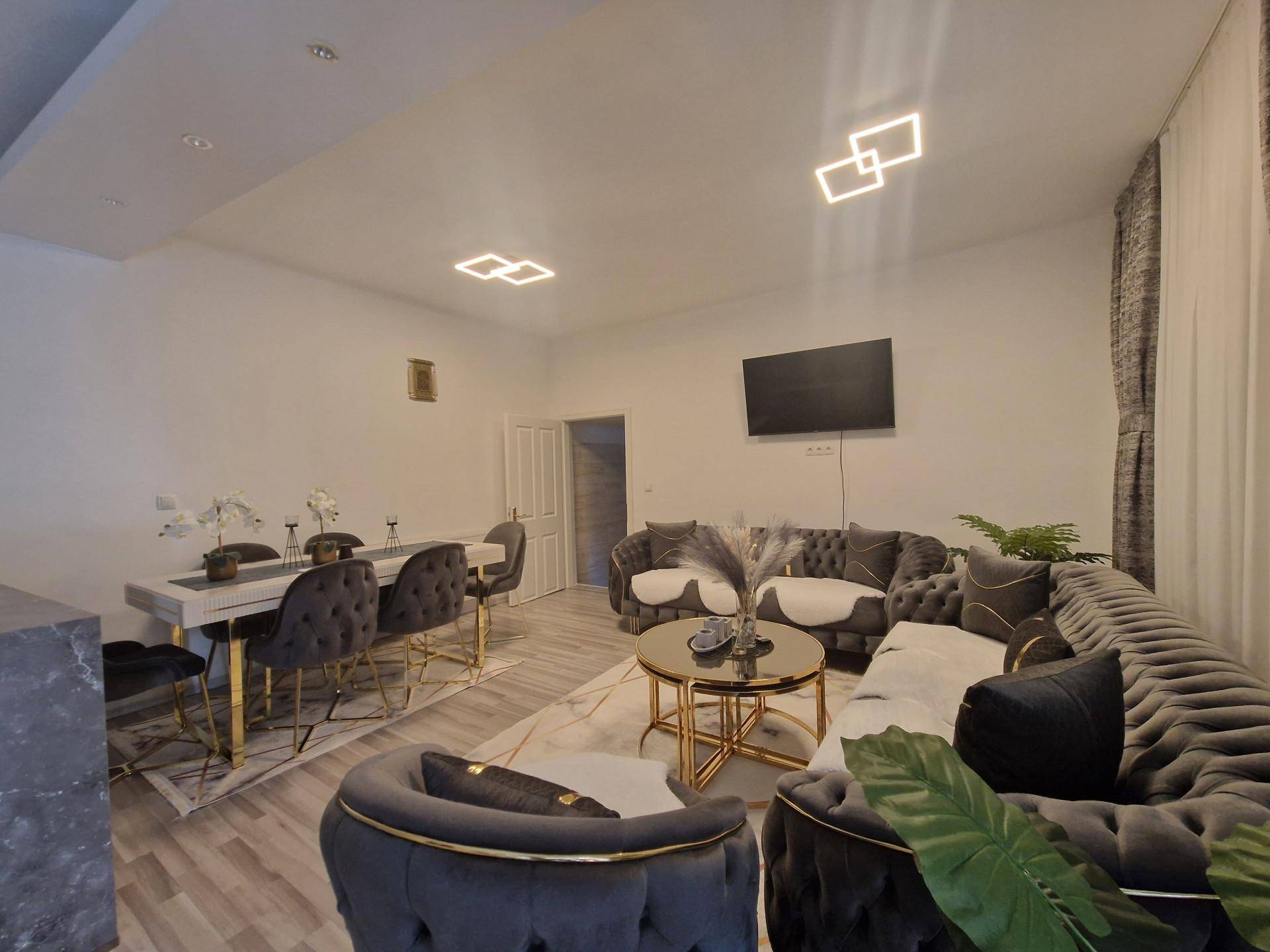 Geräumiger Wohn- und Essbereich mit modernen Möbeln, großem Sofa und stilvoller Beleuchtung.