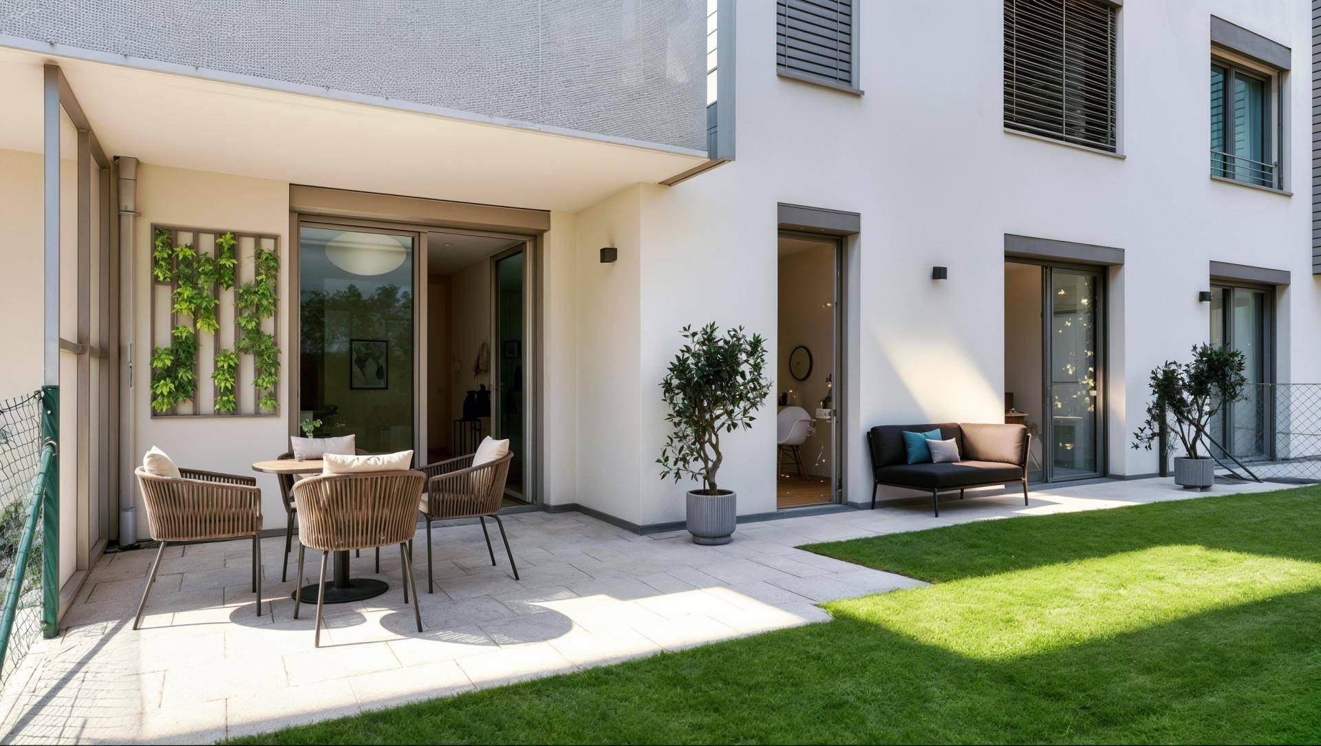 Sonniger Außenbereich mit möblierter Terrasse und gepflegtem Rasen.