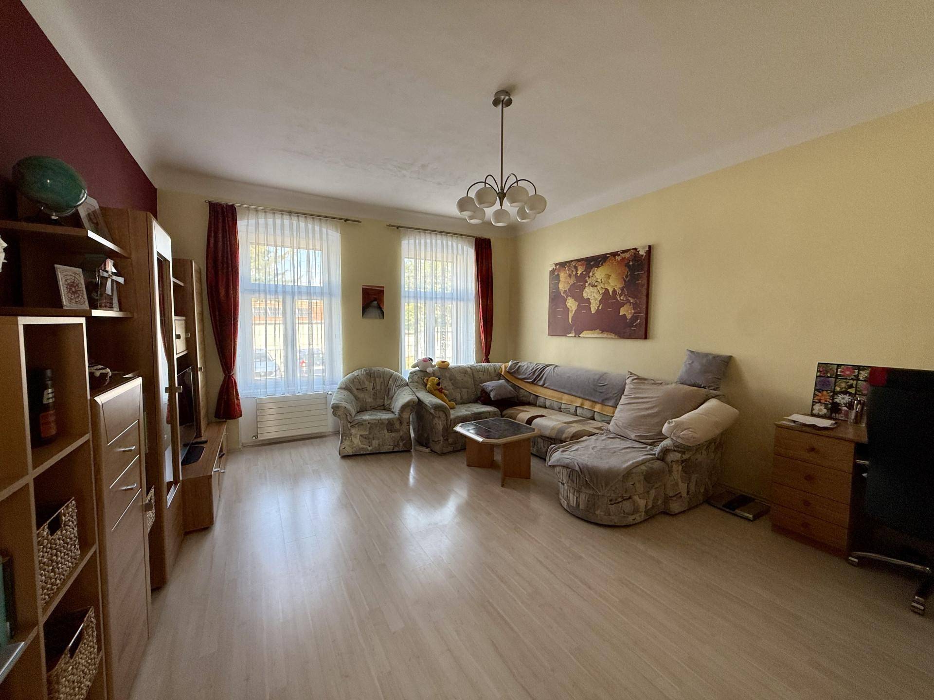 Gemütliches Wohnzimmer mit bequemen Sofas, Holzmöbeln und hellem Laminatboden, gut beleuchtet.