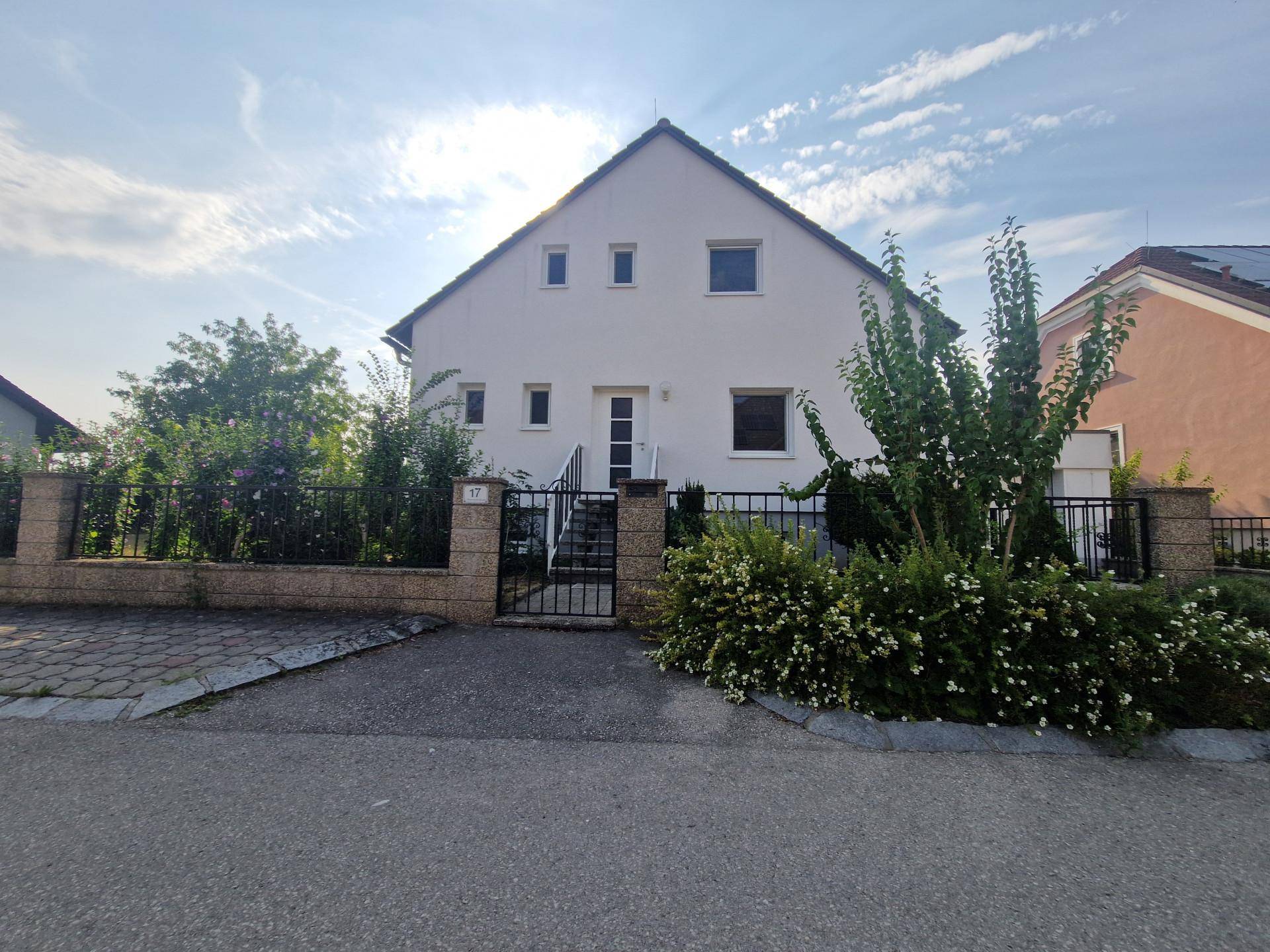 Frontansicht des Einfamilienhauses mit Eingangsbereich und gepflegtem Vorgarten.